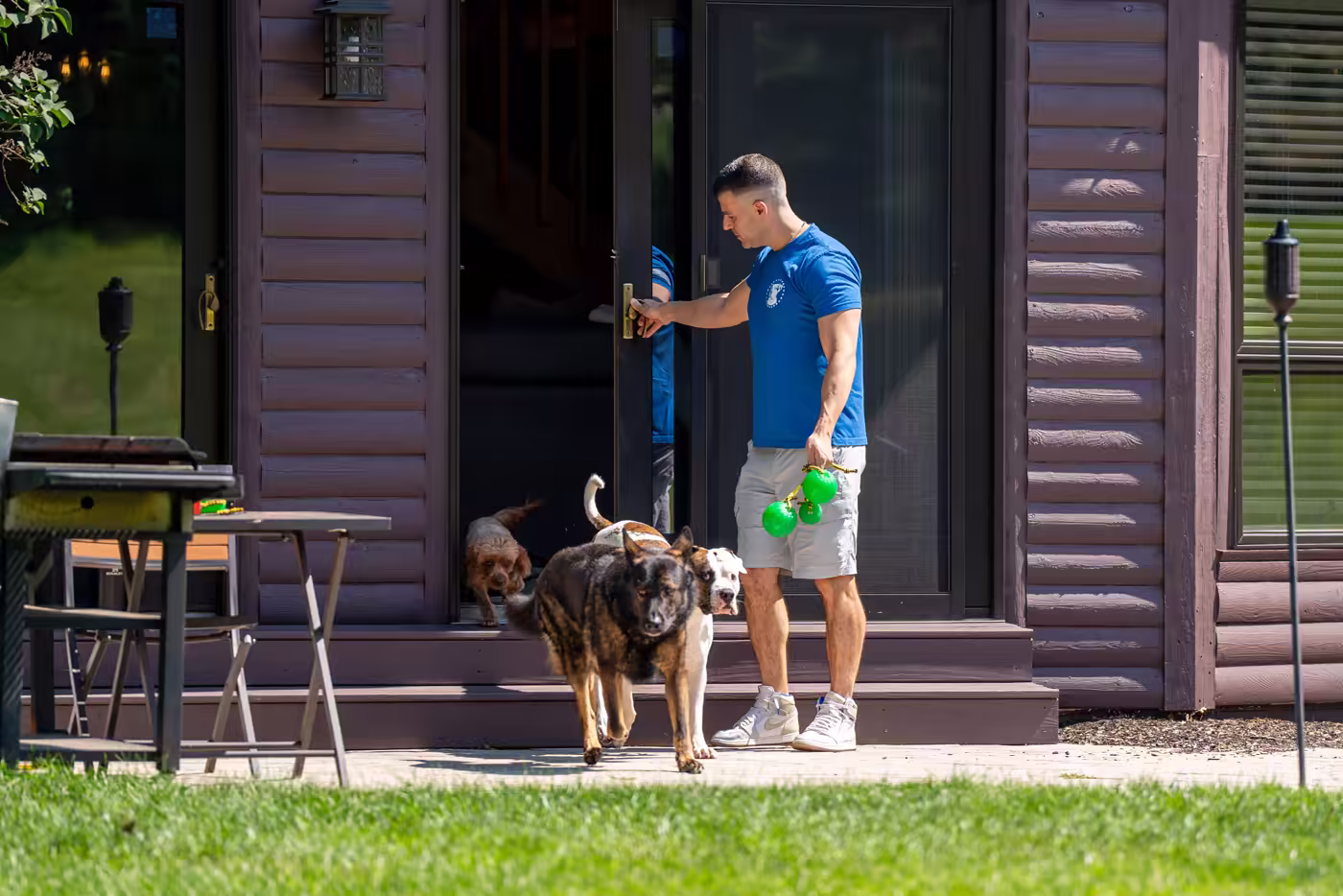 Dogs following a trainer out of the lodge door at the ranch